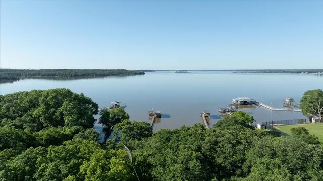 an aerial view of a house with a yard and lake view