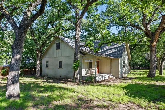 a view of a house with backyard and trees