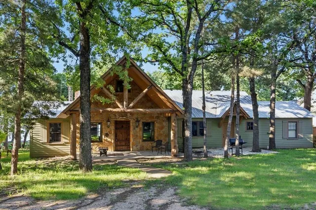 a front view of a house with a garden and trees