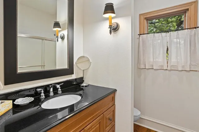 a bathroom with a granite countertop sink and a mirror