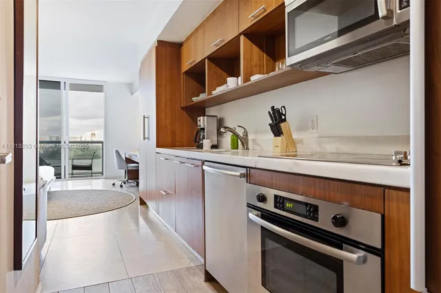 a kitchen with kitchen island wooden floor and stainless steel appliances