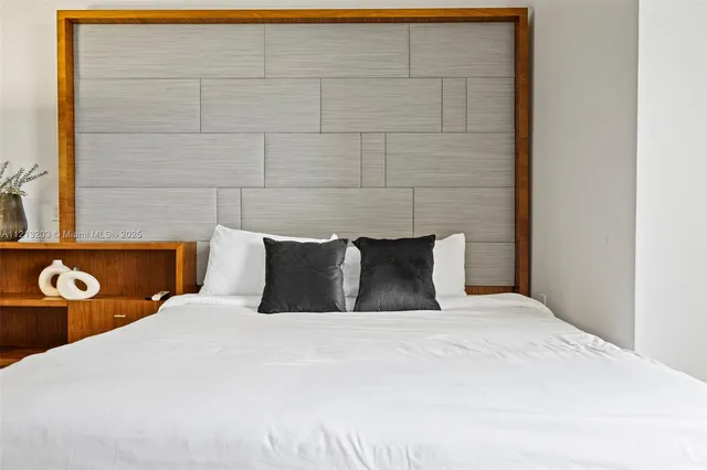 a large bed sitting in a bedroom next to a window