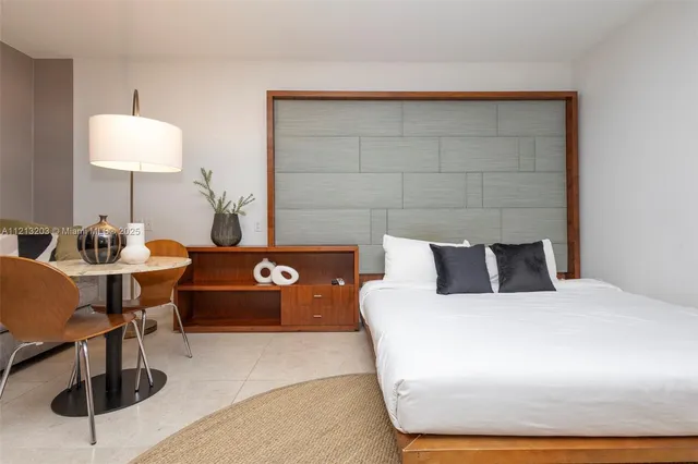 a bedroom with a bed and a lamp on table