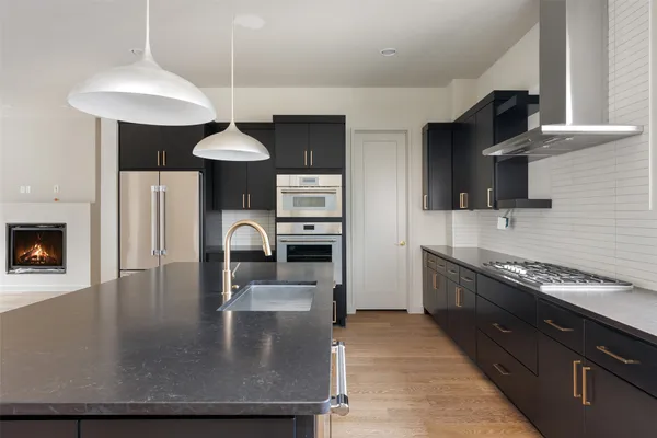 a kitchen with stainless steel appliances granite countertop a stove a sink a microwave and a refrigerator
