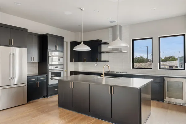 a kitchen with kitchen island a counter space a sink and stainless steel appliances