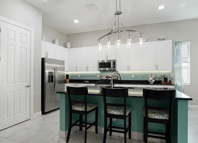 a kitchen with a table chairs refrigerator and cabinets