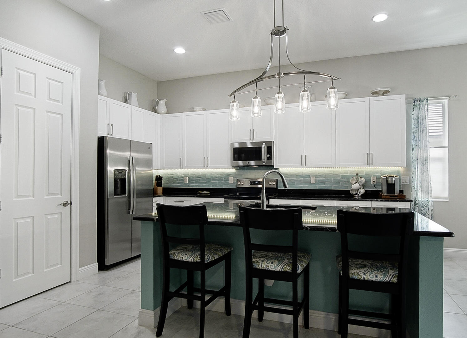 2652 Conifer Drive Fort Pierce, FL 34951 - Photo 11 of 45 a kitchen with a table chairs refrigerator and cabinets