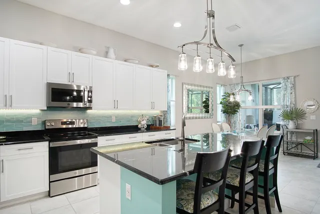 a kitchen with a stove a sink and chairs