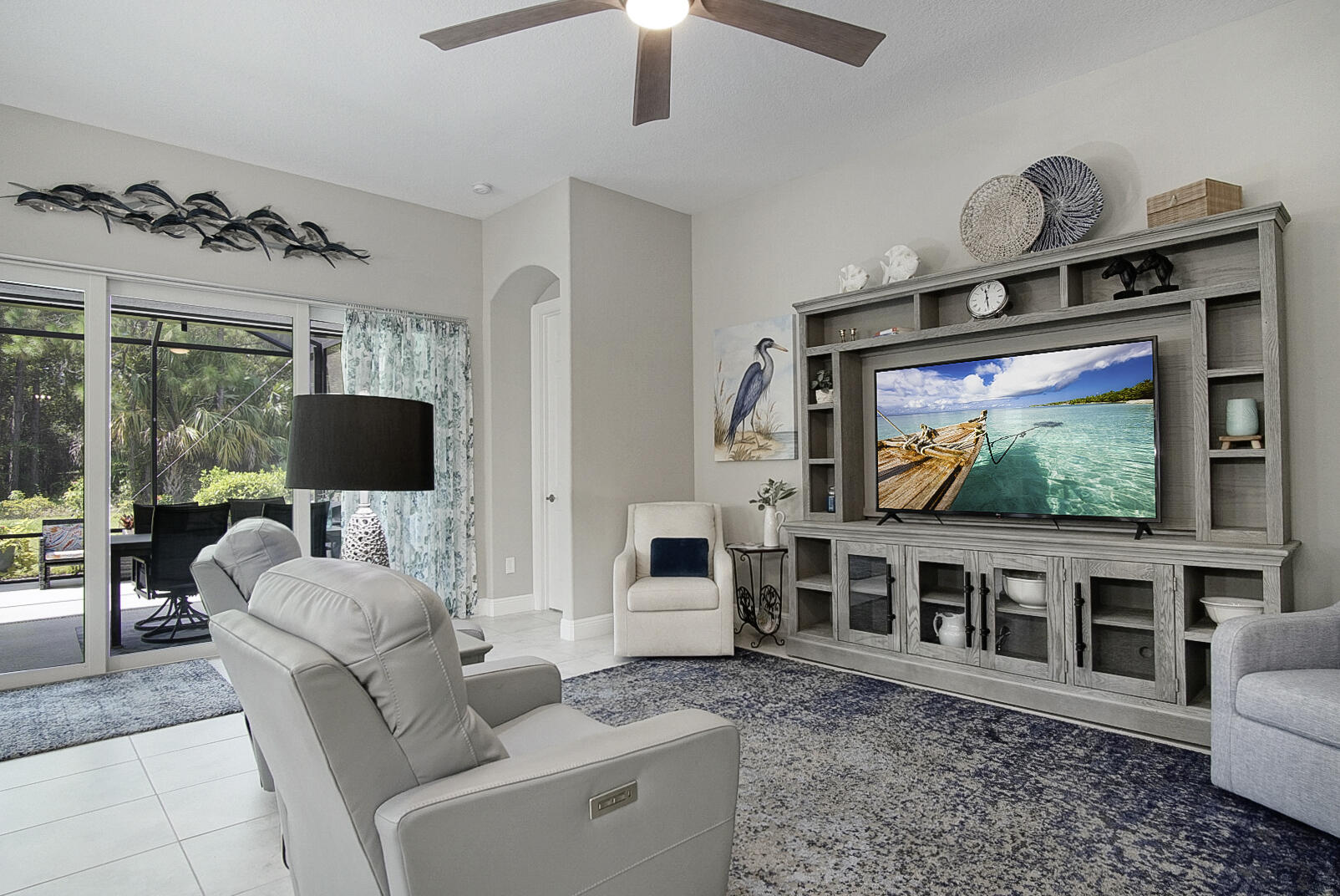 2652 Conifer Drive Fort Pierce, FL 34951 - Photo 17 of 45 a living room with furniture a flat screen tv and a floor to ceiling window