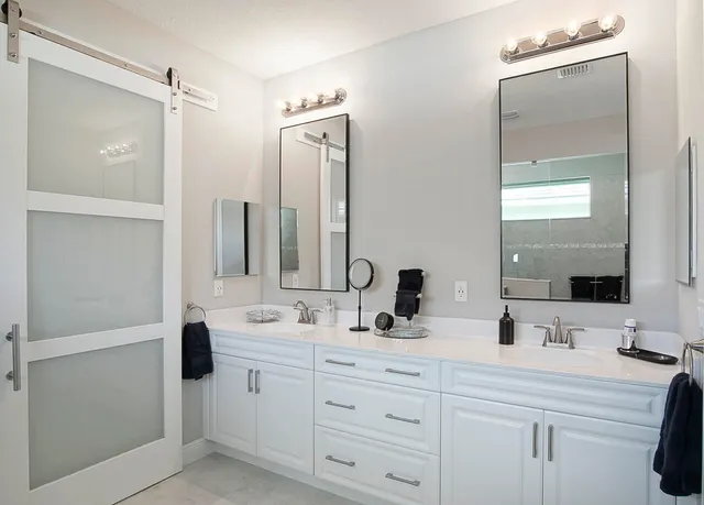 a bathroom with double vanity sink a mirror and shower
