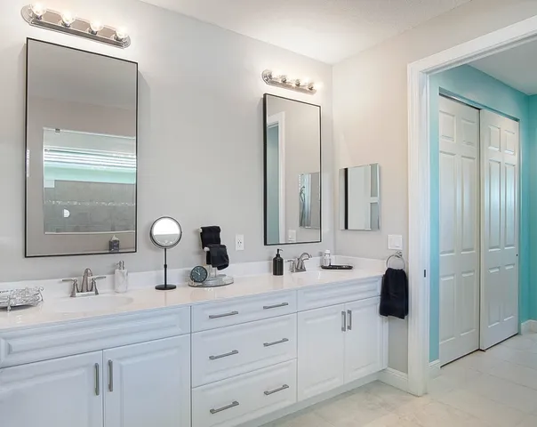 a bathroom with double vanity sinks and a mirror
