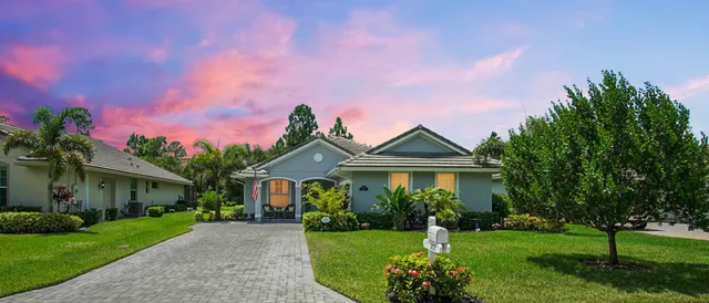 a front view of a house with a garden and plants