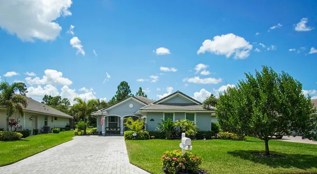 a front view of a house with a yard and potted plants