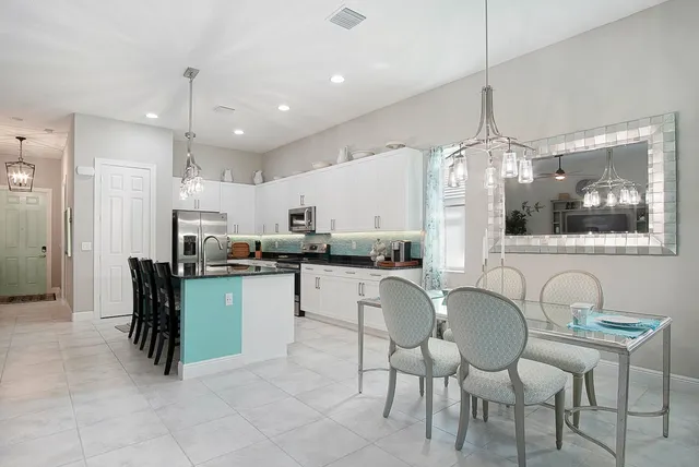 a kitchen with stainless steel appliances kitchen island granite countertop a table and chairs in it