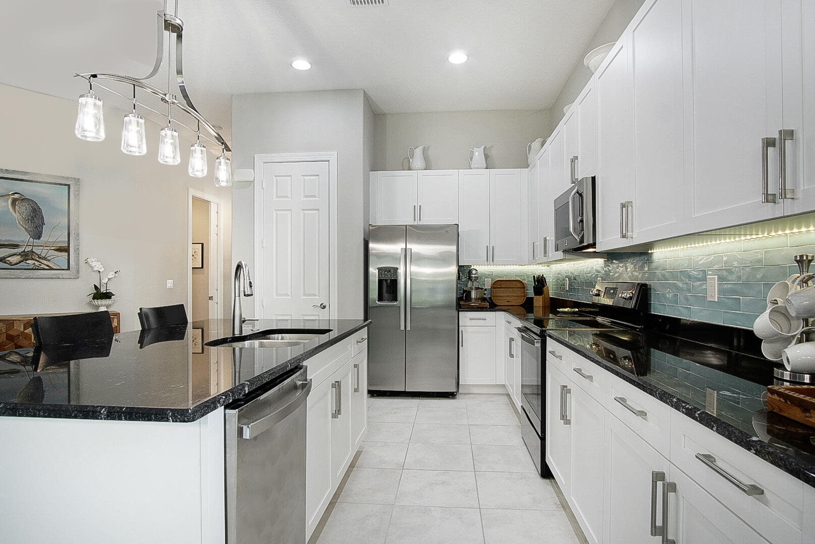 2652 Conifer Drive Fort Pierce, FL 34951 - Photo 10 of 45 a kitchen with stainless steel appliances granite countertop a sink a stove and a refrigerator
