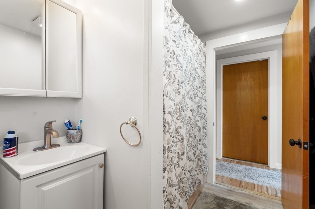 129 Friend Street Amesbury, MA 01913 - Photo 12 of 37 a bathroom with a shower curtain and a sink