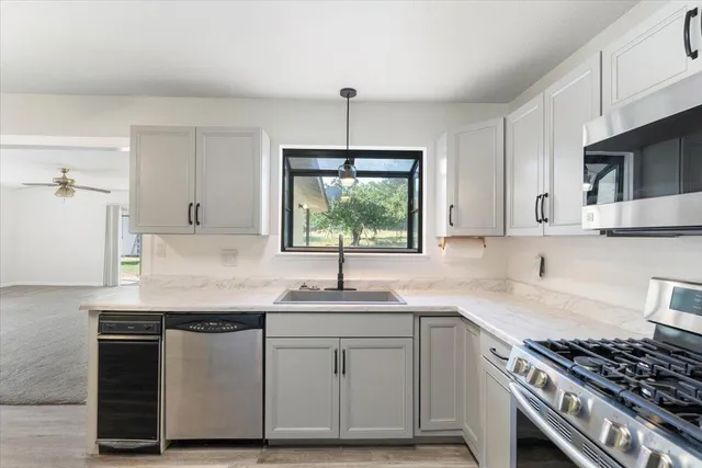a kitchen with stainless steel appliances granite countertop a sink stove and cabinets