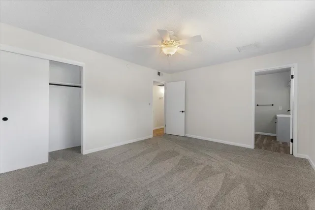 a view of an empty room with a chandelier fan