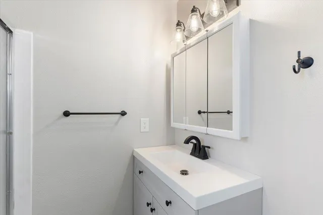 a bathroom with a sink vanity and mirror