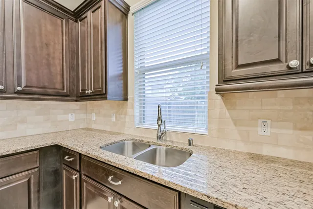 a kitchen with granite countertop a sink and cabinets