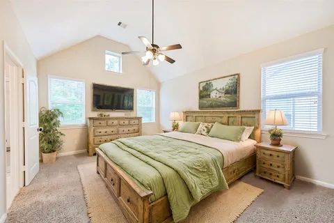 a spacious bedroom with a bed and a flat screen tv