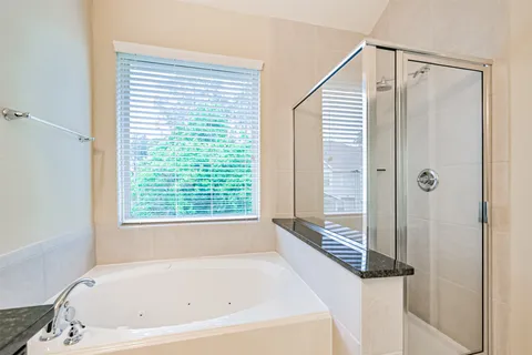 a white bath tub sitting next to a shower