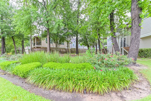 a backyard of a house with lots of green space and fountain