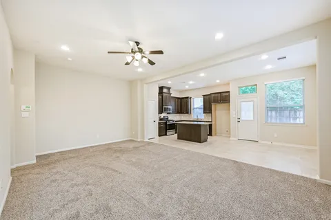 a view of an empty room with a kitchen