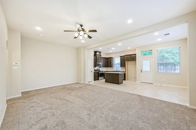 a view of an empty room with a kitchen