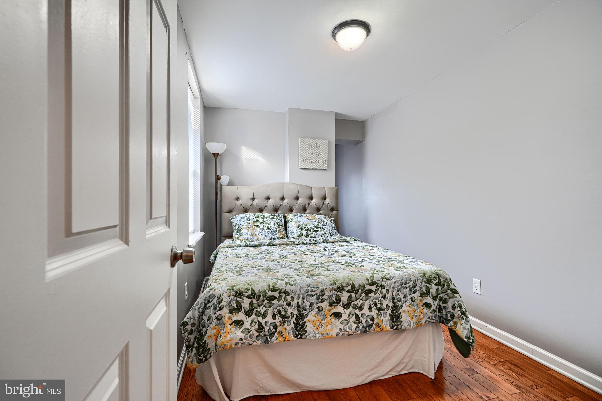 1410 East Oliver Street Baltimore, MD 21213 - Photo 29 of 40 a bed sitting in a bedroom next to a window