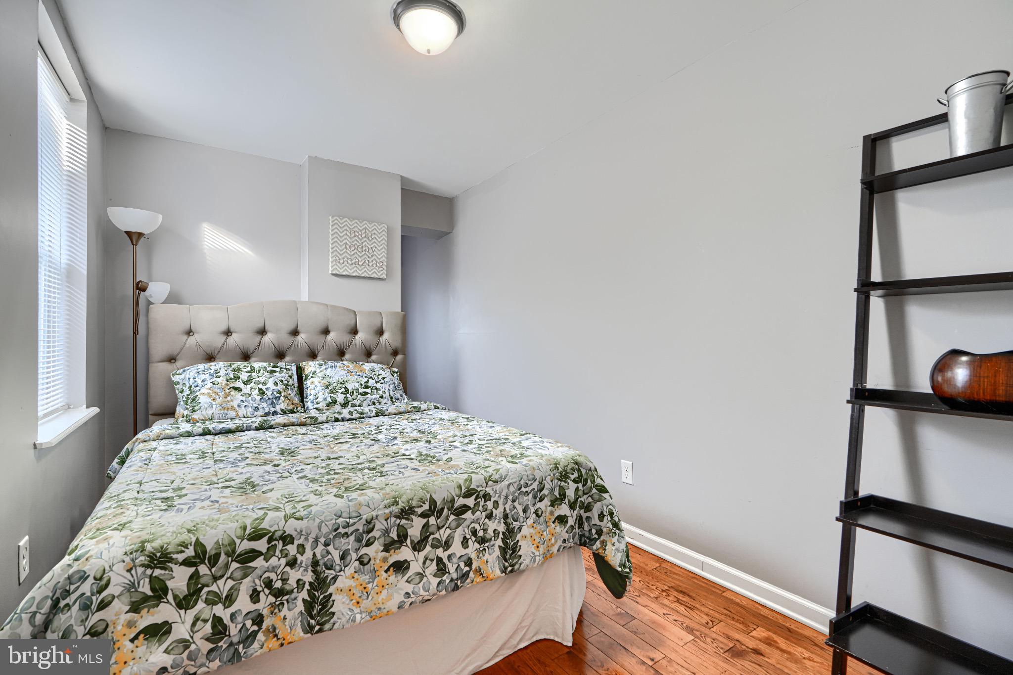 1410 East Oliver Street Baltimore, MD 21213 - Photo 30 of 40 a bedroom with a bed and wooden floor