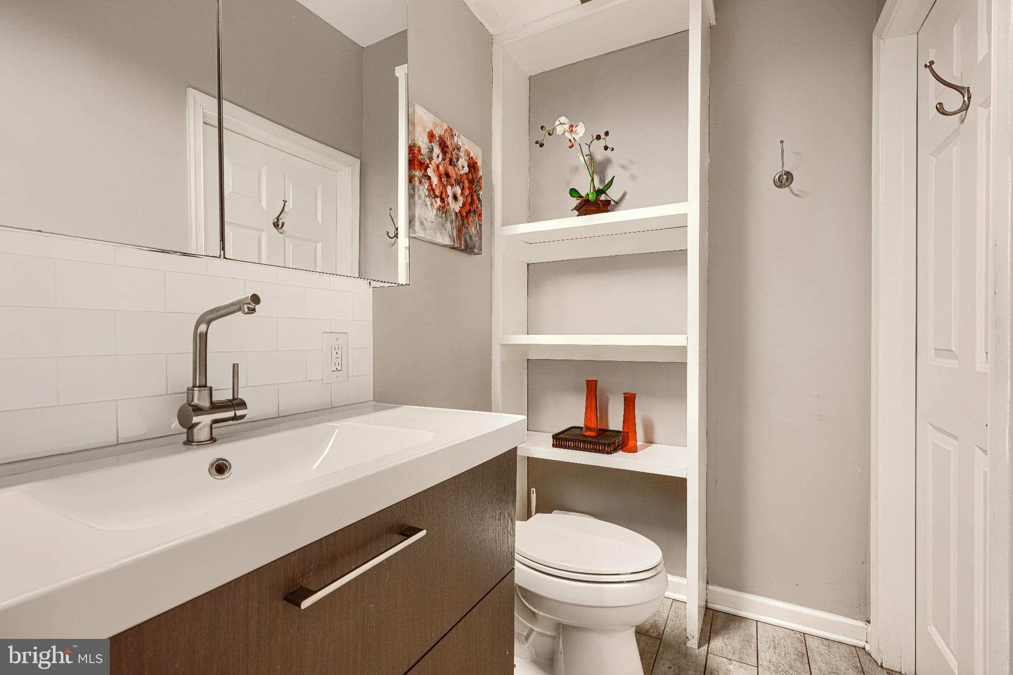 1410 East Oliver Street Baltimore, MD 21213 - Photo 36 of 40 a bathroom with a sink a toilet and a mirror