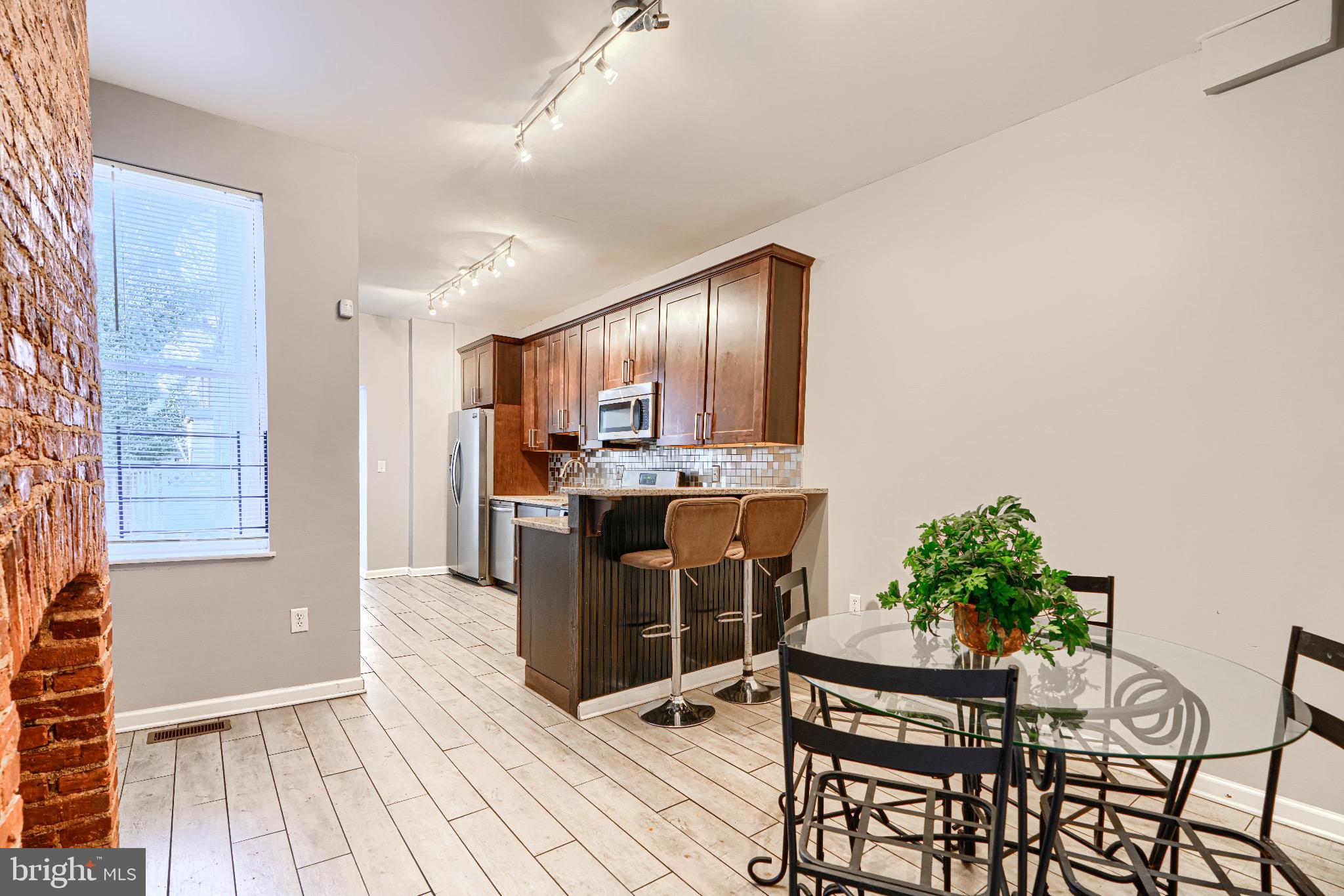 1410 East Oliver Street Baltimore, MD 21213 - Photo 9 of 40 a kitchen with a table and chairs in it