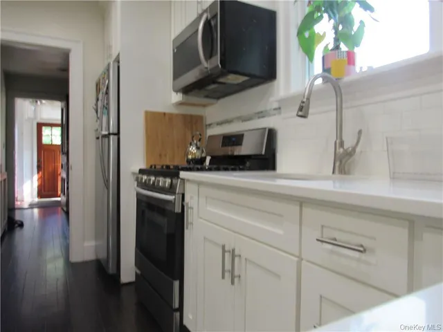 a kitchen with stainless steel appliances white cabinets and a sink