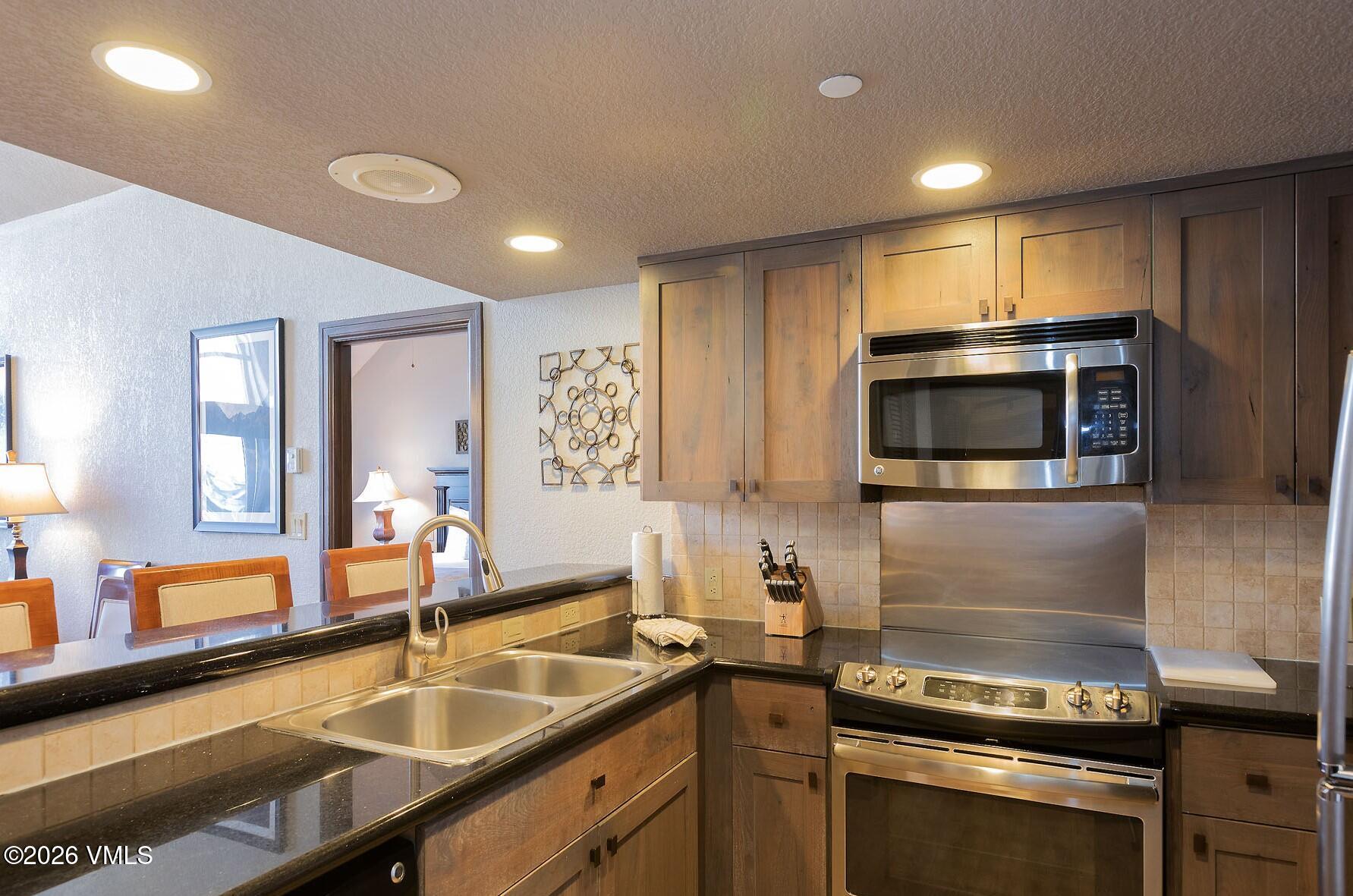 210 Offerson Road, Unit 41912 Beaver Creek, CO 81620 - Photo 4 of 28 a kitchen with a sink and stainless steel appliances