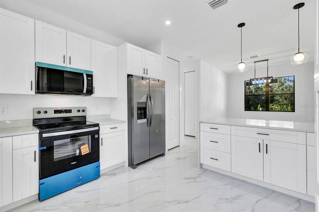 2002 East 10th Street Lehigh Acres, FL 33936 - Photo 12 of 25 a kitchen with cabinets stainless steel appliances and wooden floor