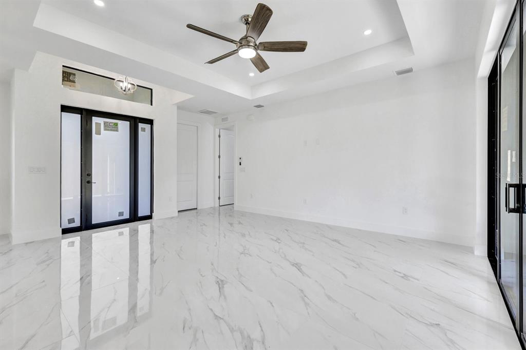 2002 East 10th Street Lehigh Acres, FL 33936 - Photo 13 of 25 an empty room with a ceiling fan and carpet