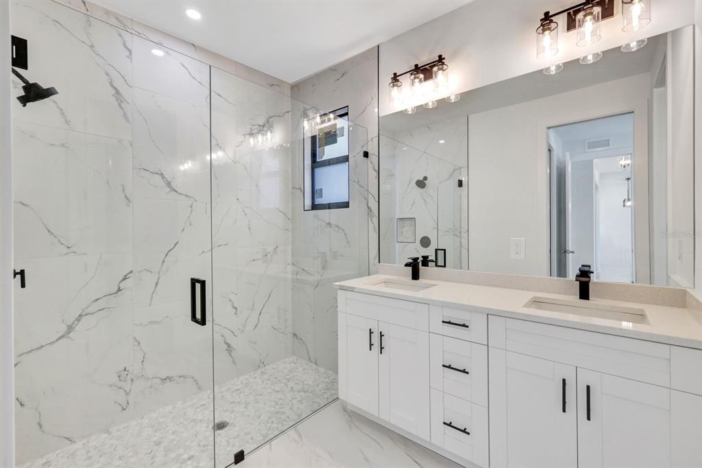 2002 East 10th Street Lehigh Acres, FL 33936 - Photo 17 of 25 a bathroom with a double vanity sink mirror and shower