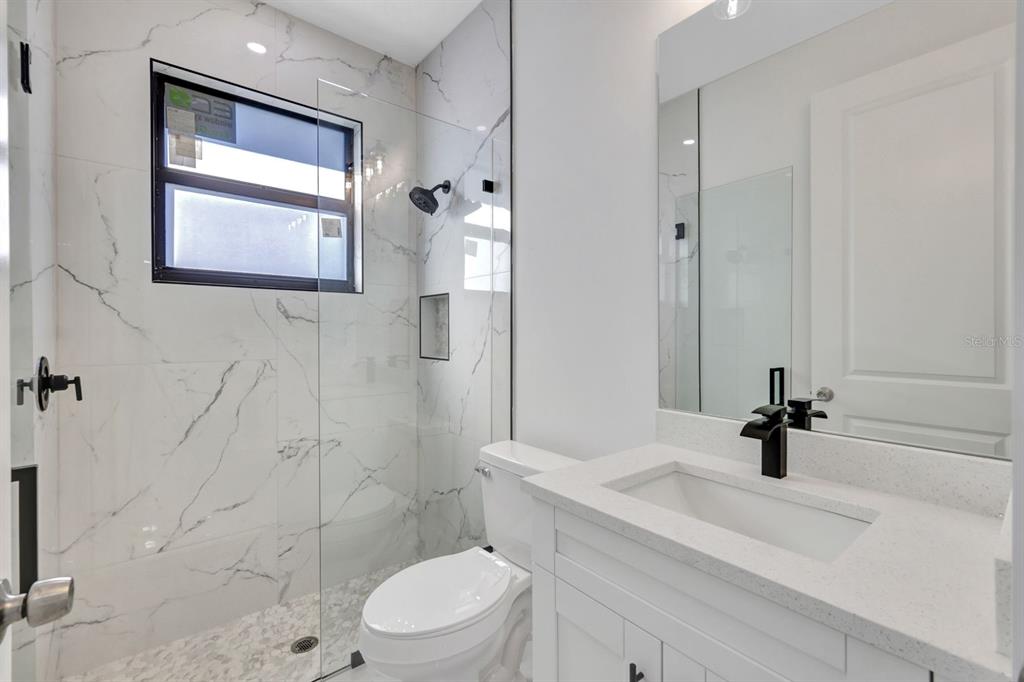 2002 East 10th Street Lehigh Acres, FL 33936 - Photo 19 of 25 a bathroom with a sink a toilet and shower