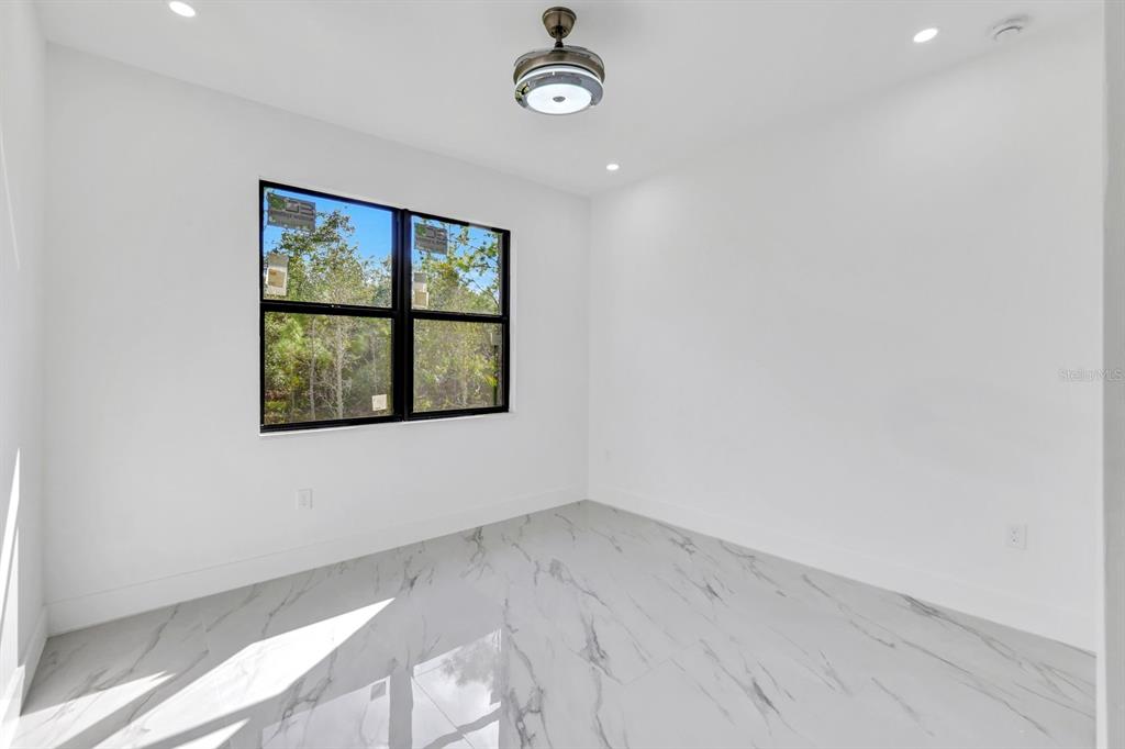 2002 East 10th Street Lehigh Acres, FL 33936 - Photo 20 of 25 an empty room with wooden floor and windows