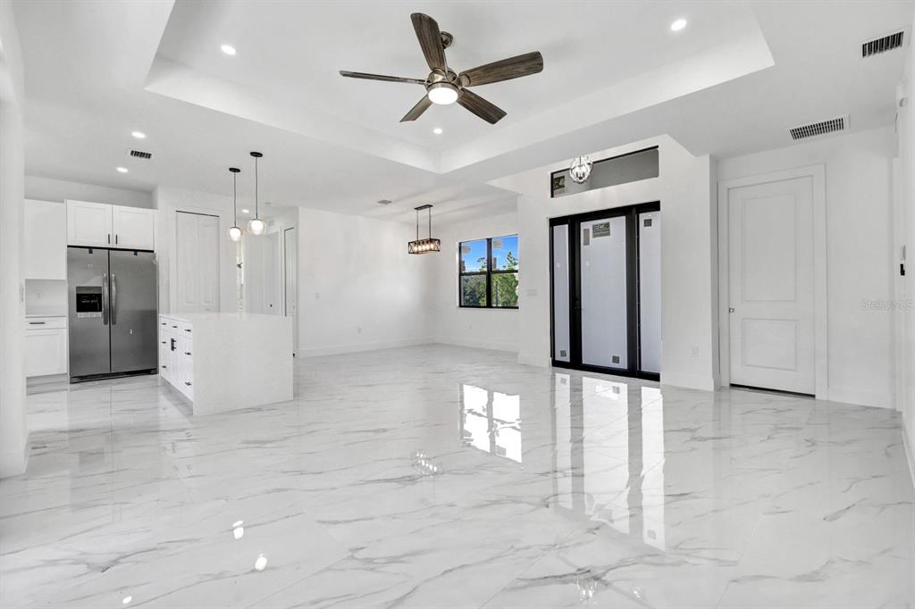 2002 East 10th Street Lehigh Acres, FL 33936 - Photo 3 of 25 a view of a big room with a chandelier fan and windows