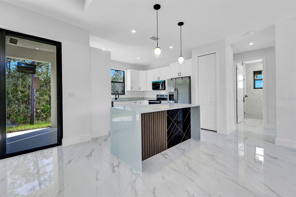 2002 East 10th Street Lehigh Acres, FL 33936 - Photo 8 of 25 a kitchen with kitchen island a sink stainless steel appliances and cabinets