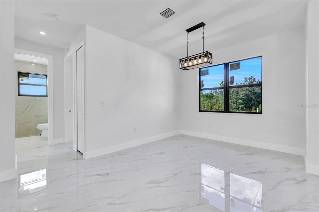 2002 East 10th Street Lehigh Acres, FL 33936 - Photo 9 of 25 a view of empty room with wooden floor and fan