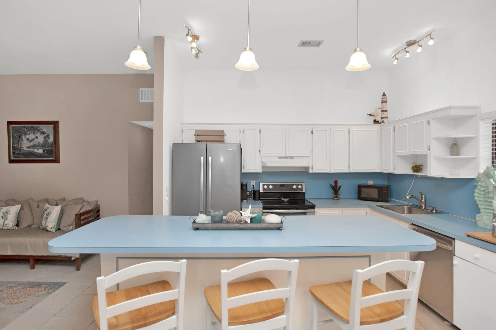 80 Seagate Boulevard Key Largo, FL 33037 - Photo 19 of 46 a kitchen with kitchen island a stove a sink dishwasher and white cabinets with wooden floor