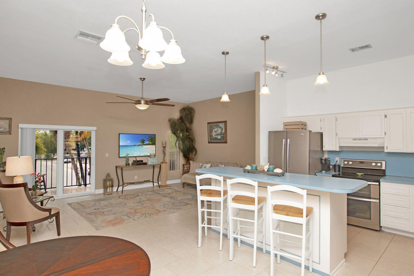 80 Seagate Boulevard Key Largo, FL 33037 - Photo 20 of 46 a dining room with wooden floor a chandelier a wooden table and chairs