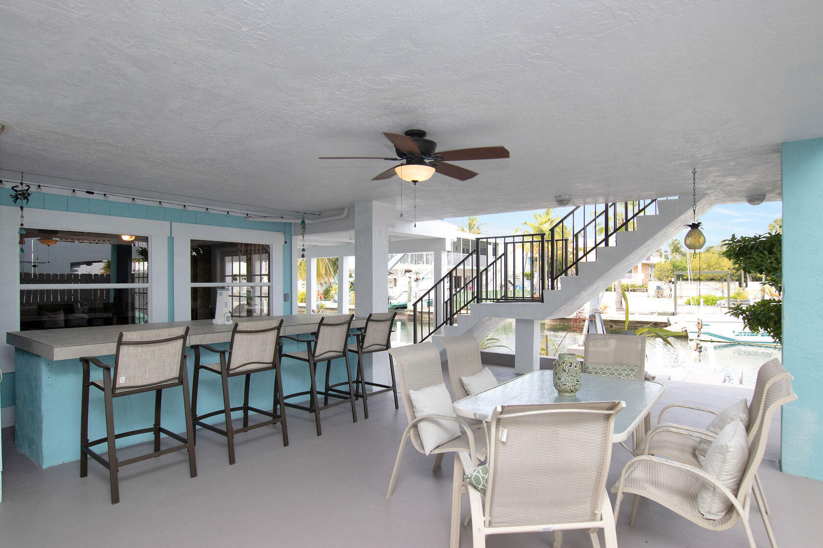 80 Seagate Boulevard Key Largo, FL 33037 - Photo 7 of 46 a living room with furniture a rug and a chandelier