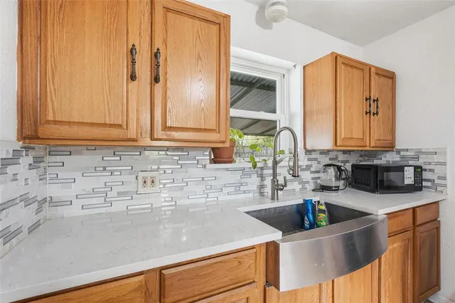 a kitchen with granite countertop a sink a stove and cabinets