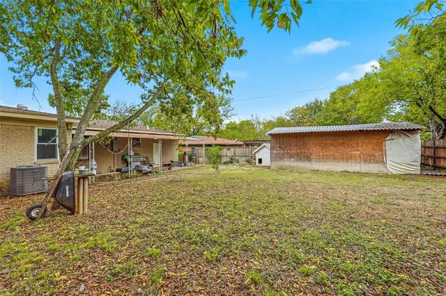 a view of a yard with a house and a large tree