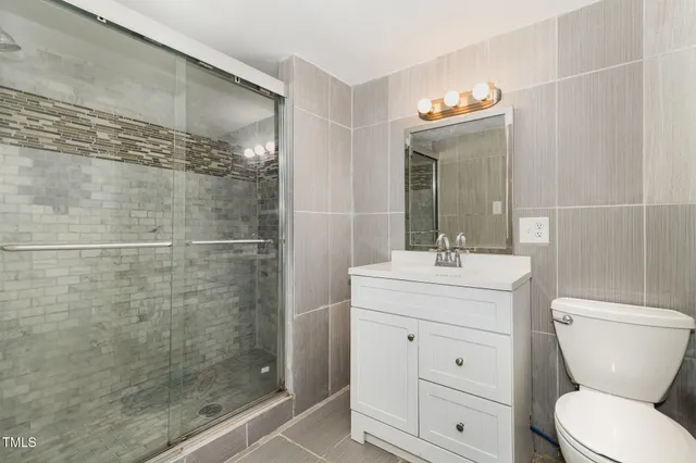 a bathroom with a granite countertop sink a toilet and a mirror