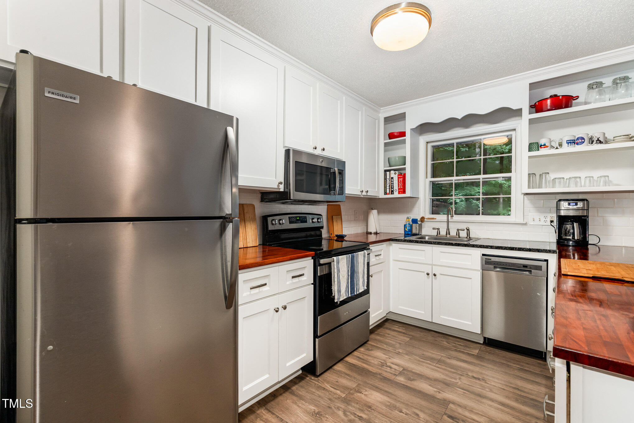 2900 Beechgrove Drive Durham, NC 27705 - Photo 4 of 32 a kitchen with stainless steel appliances a refrigerator sink and microwave